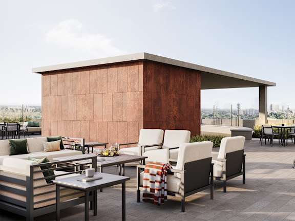 A patio with a table and chairs with a brown building in the background.