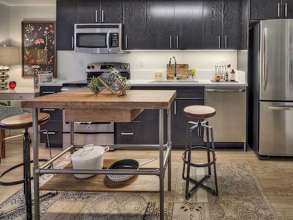 a kitchen with stainless steel appliances and a wooden table