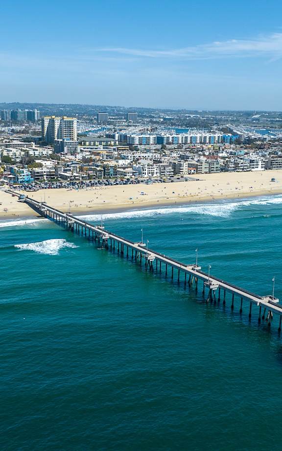 a view of the pier from the air with the beach and city in the background