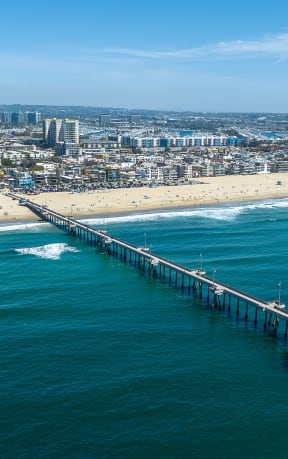 a view of the pier from the air with the beach and city in the background