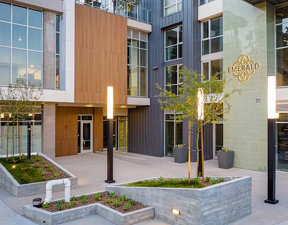 emerald apartment building entrance with modern landscaping