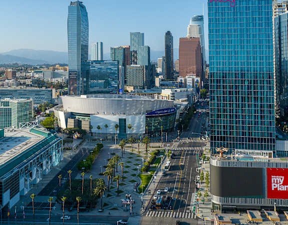 A cityscape with a large building in the foreground and a clear sky above.
