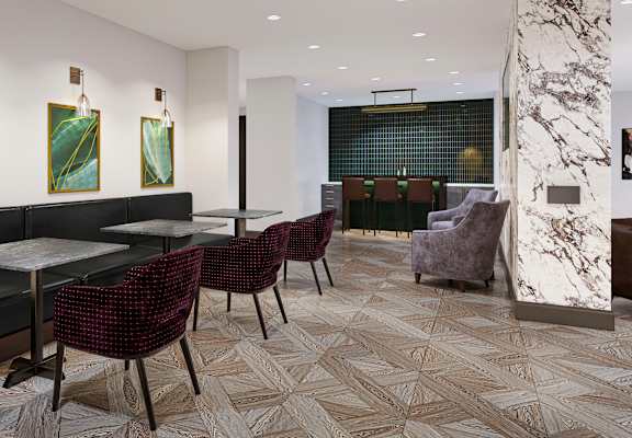 a room with tables and chairs and a bar in the background