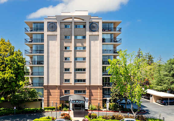 A large apartment building with a parking lot in front.