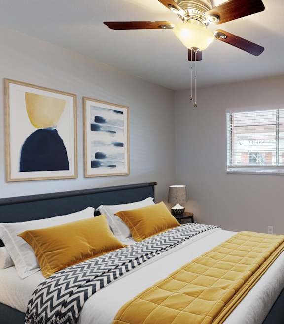 A bedroom with a bed, a mirror, and a ceiling fan.