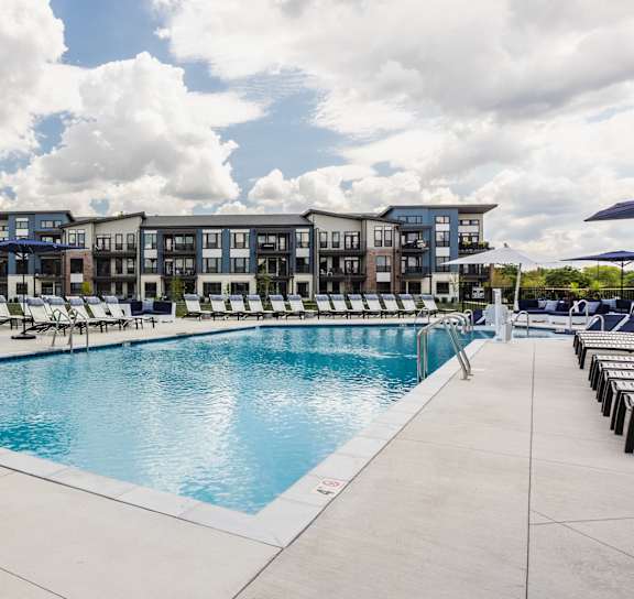 a woman holding a baby in a swimming pool at Upper Vue Flats, Dublin, Ohio