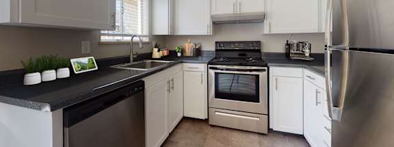 A modern kitchen with stainless steel appliances and white cabinets.