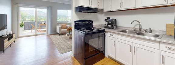 A kitchen with white cabinets and a black stove top oven.