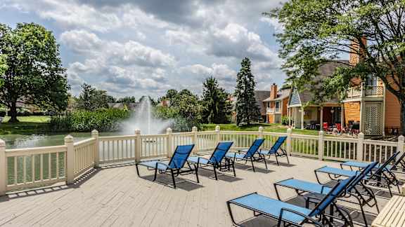A large swimming pool surrounded by lounge chairs and umbrellas.