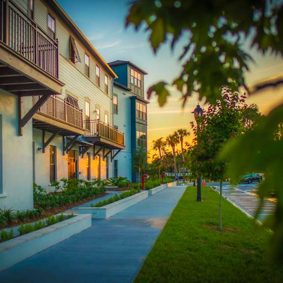 A row of houses with a sidewalk in front.