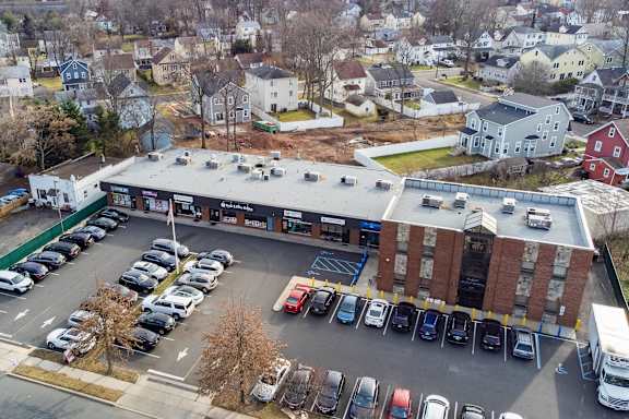 an aerial view of a parking lot and a building with cars parked