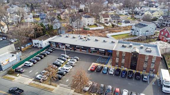 an aerial view of a parking lot and a building with cars parked