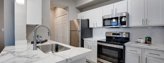 Kitchen with white cabinets and stainless steel appliances  at Carmel Creekside, Fort Worth