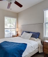 a bedroom with a large bed and a ceiling fan