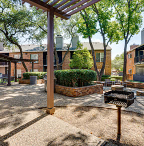 our apartments have a spacious courtyard with a grill and trees at The Manhattan Apartments, Dallas, TX, 75252