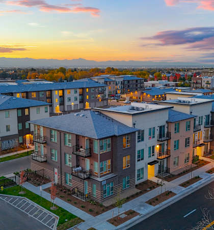 A sunset view of a residential area with apartment buildings.