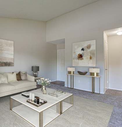 A living room with a white couch, a coffee table, and a painting on the wall.