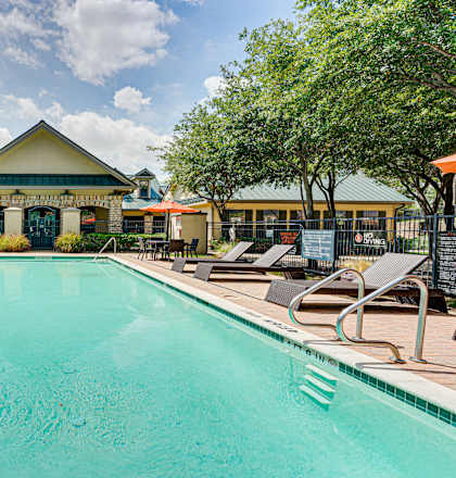 A large swimming pool in front of a building with a yellow roof.