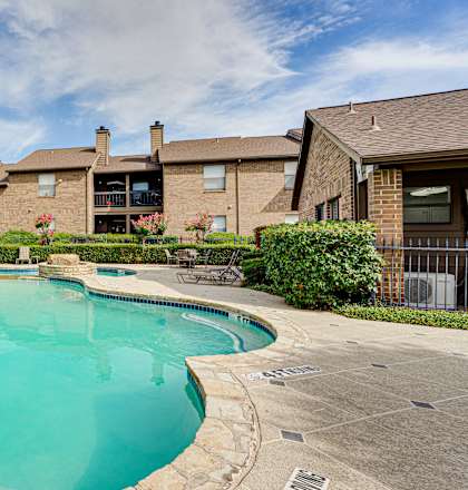 A swimming pool in a residential area with houses in the background.