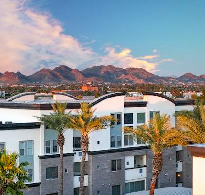 Level at Sixteenth building and palm trees in the foreground and mountains in the background.