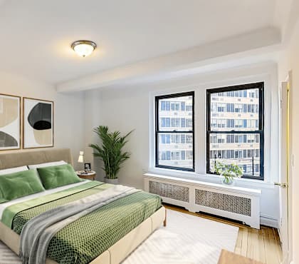 A bedroom with a large bed and a chair by the window. at Sutton Collection Apartments, New York, New York
