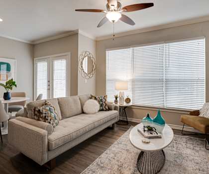 a living room with a ceiling fan and a couch  at The Brazos, Dallas