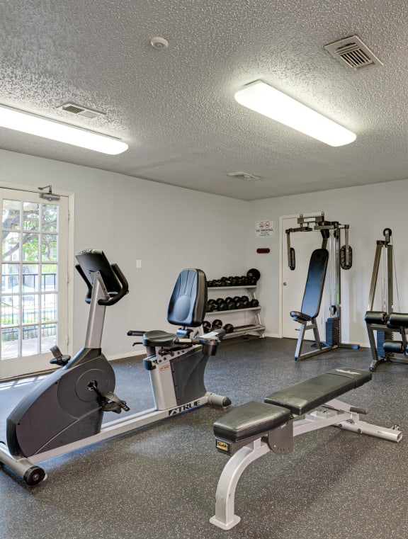 a gym with various exercise equipment and a window