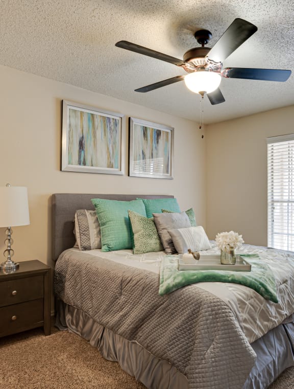 an overview of a bedroom with a large bed and a ceiling fan