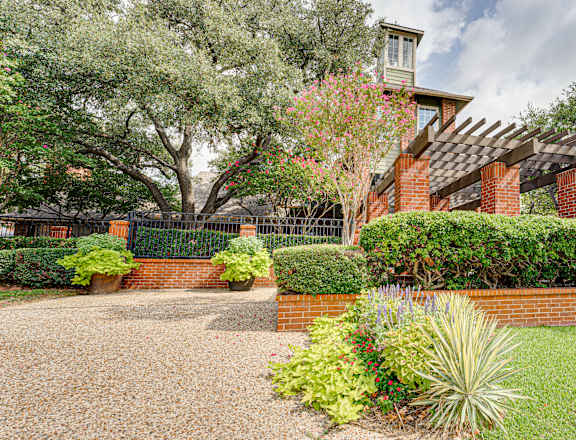 A house with a gravel driveway and a brick wall.