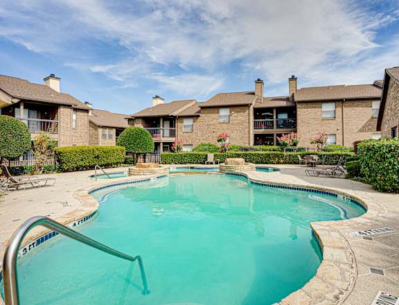 A swimming pool in a residential area with houses in the background.