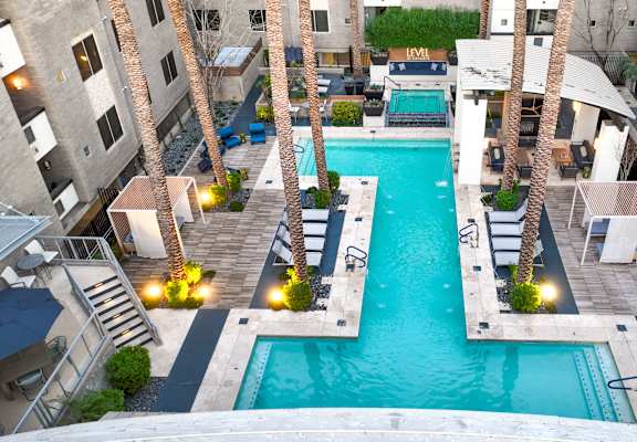 A swimming pool surrounded by palm trees and buildings.