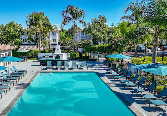 A large swimming pool surrounded by lounge chairs and umbrellas at Missions at Chino Hills, Chino Hills, CA