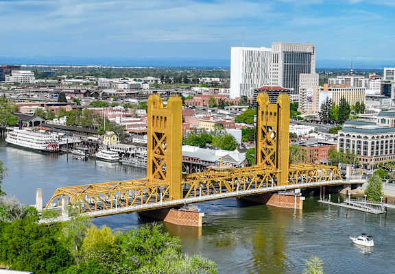 yellow bridge in sacramento with boats in the river