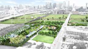 A cityscape with a green park in the foreground.