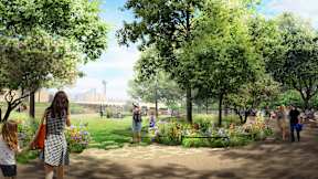 A family is walking through a park with a lot of greenery and flowers.