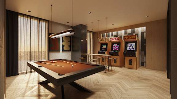 A pool table is in the middle of a room with a row of arcade machines.