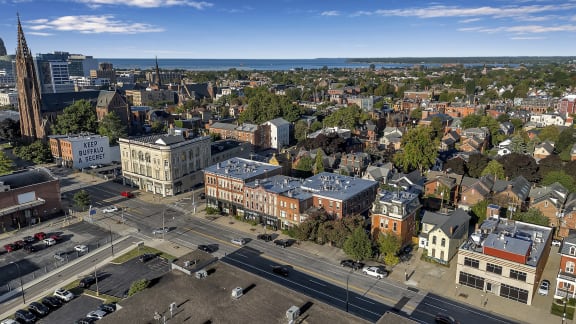 an aerial view of the city with the ocean in the background at The Granite Works Apartments , New York 14202