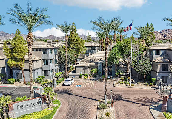 The entrance to a residential complex with a flag flying in the background.