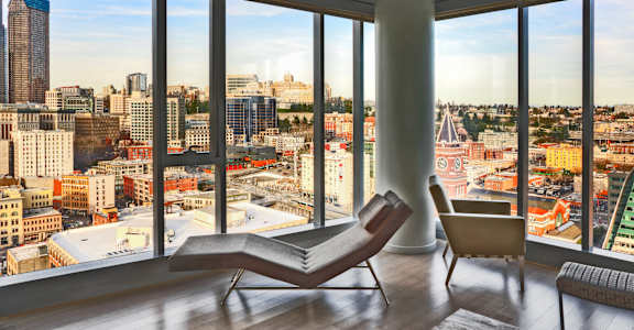 a living room with a chair and a view of the city