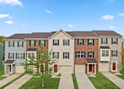 Thumbnail 2 of 16 - A row of houses with a tree in front of the middle house.