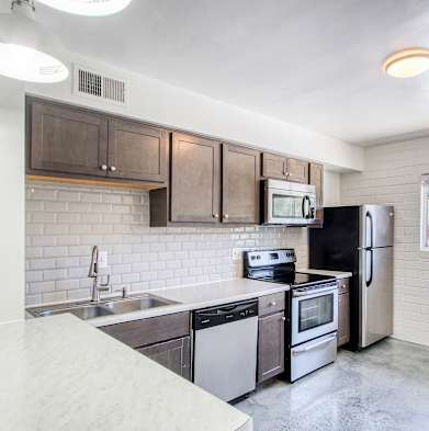 a kitchen with wooden cabinets and stainless steel appliances