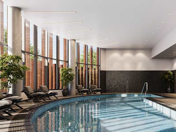 A large indoor swimming pool with lounge chairs and a sunken seating area.
