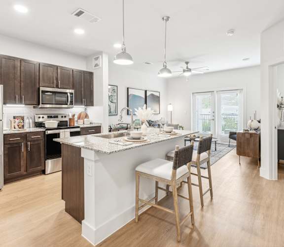 A kitchen with a white island and wooden floors.