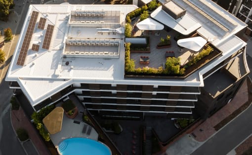 an aerial view of a building with a pool and courtyard