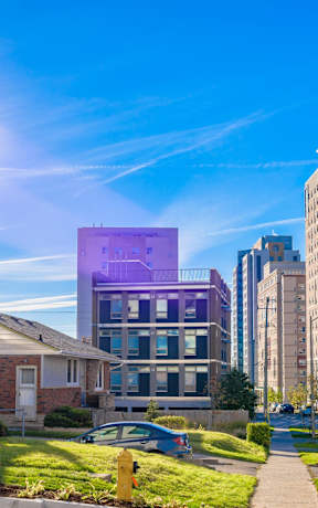 A sunny day in a residential area with a purple building in the middle.