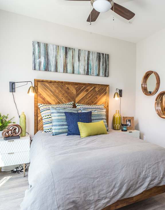 A bedroom with a bed, a chair, and a ceiling fan.