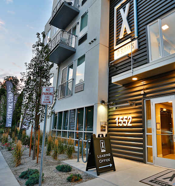 A modern multi-story building with a mix of grey and brown exterior walls.