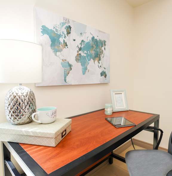A table with a laptop and a cup on it.