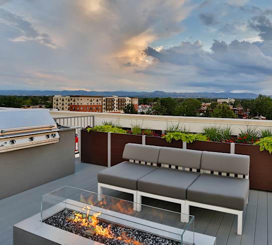 A patio with a fire pit and seating area.