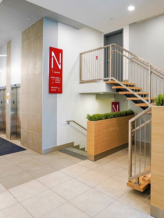 the lobby of a building with a staircase and a reception desk